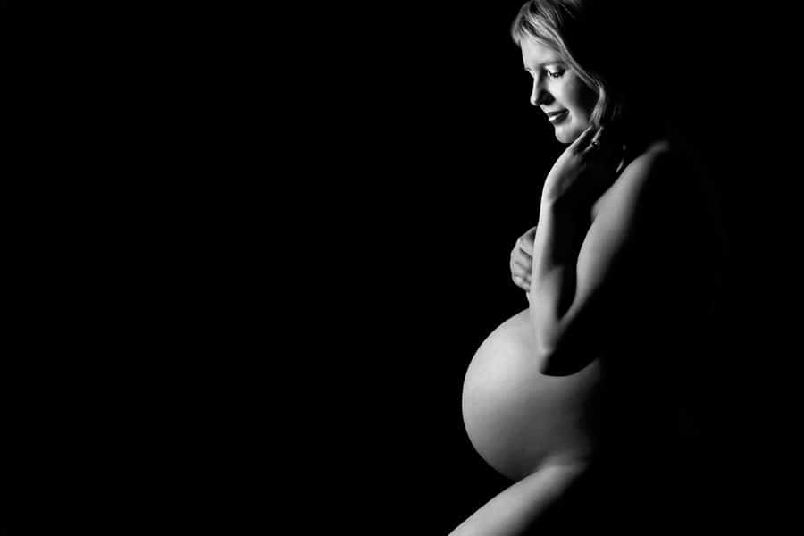 black and white of the beautiful shape of a pregnant woman taken in low lighting at Lifeworks photography, Melbourne