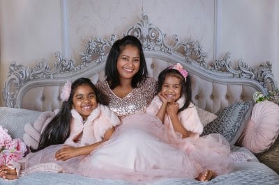 mother and daughters on bed