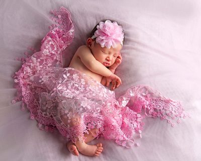 pink newborn props with sleeping baby girl 