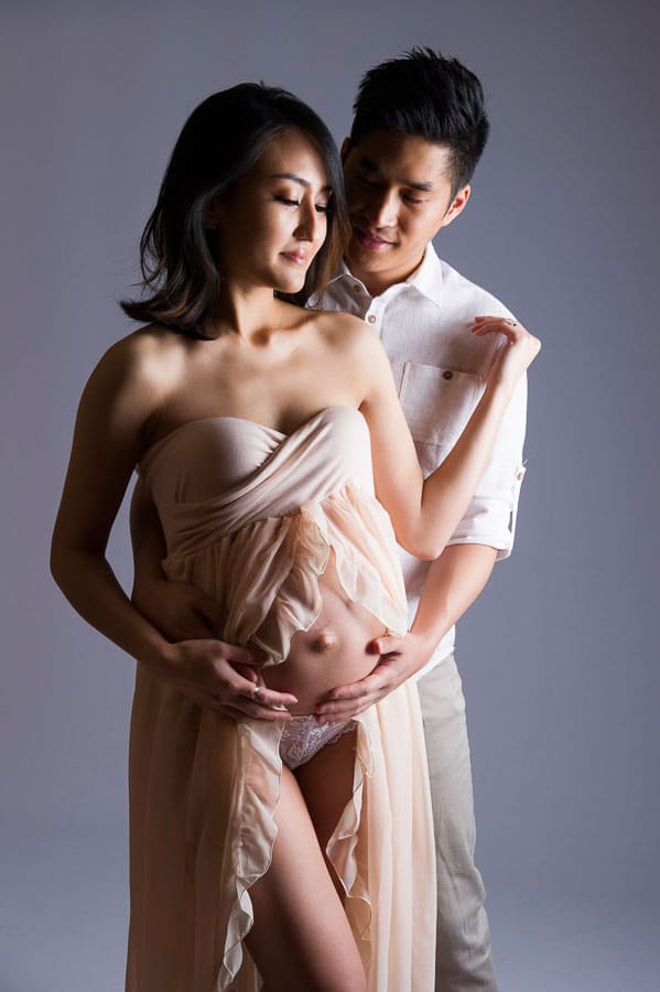 a loving pregnant couple enjoying a tender moment in the studio